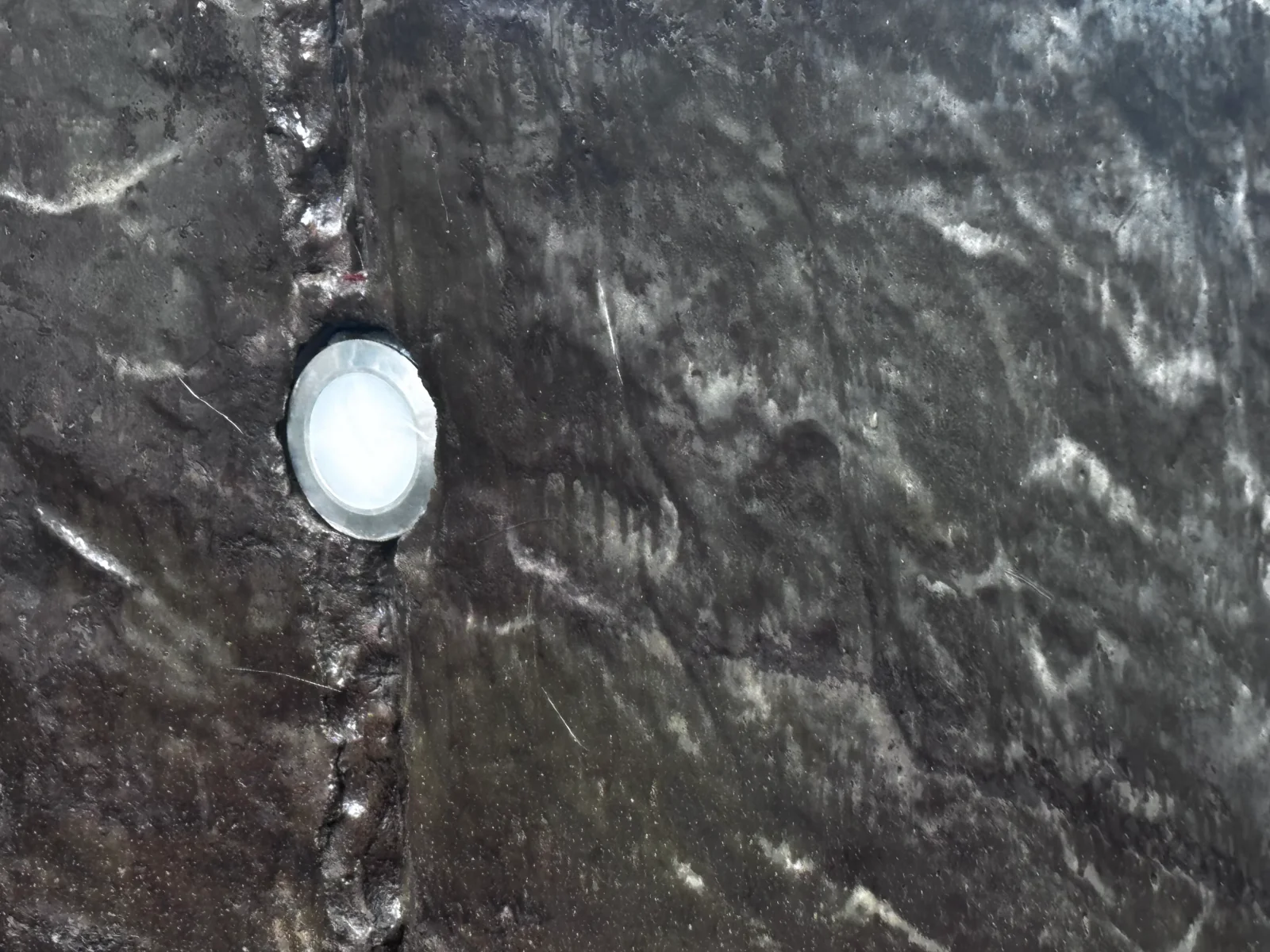 Recessed LED light fixture installed in textured concrete surface