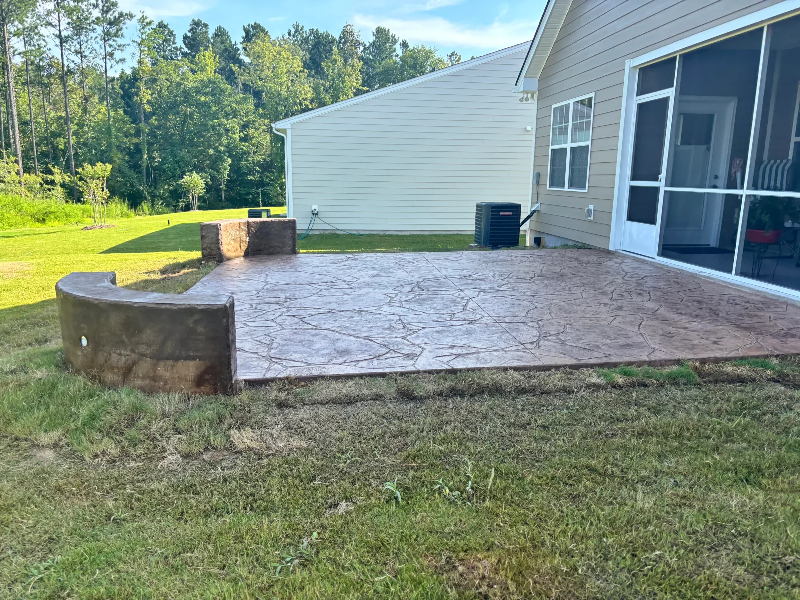 Stamped concrete patio with slate pattern finish next to residential home