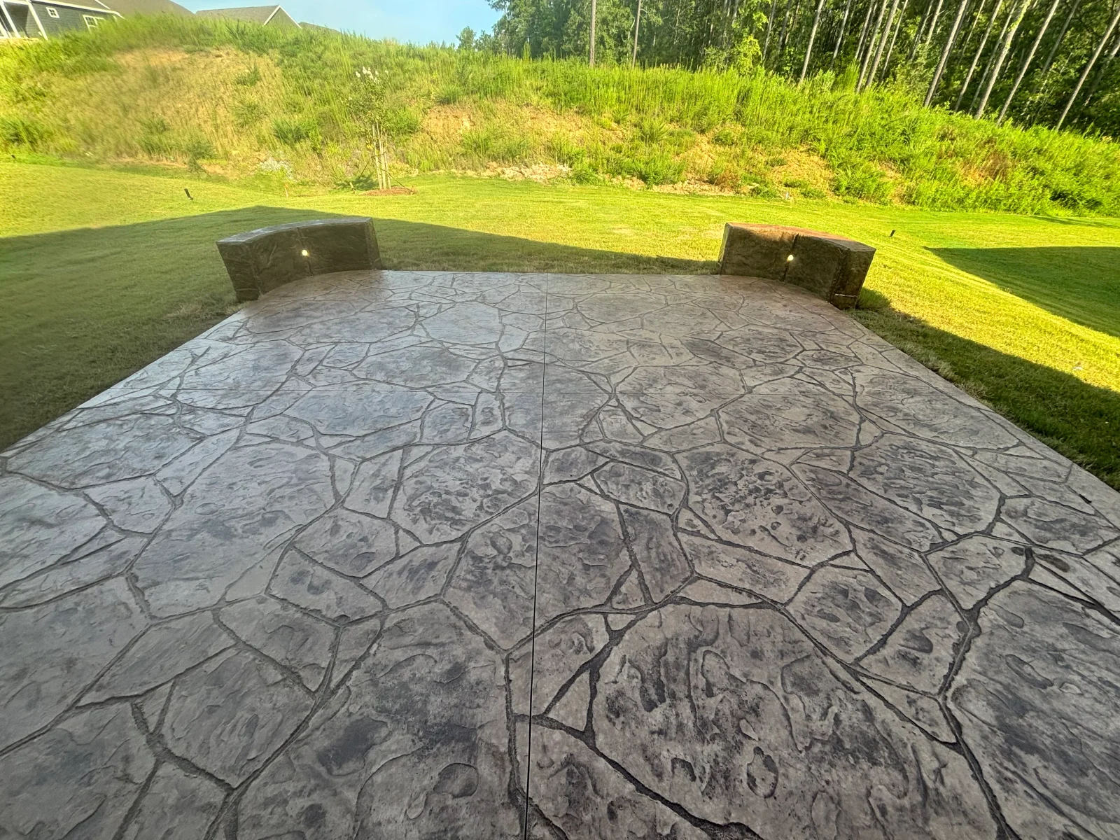 Stamped concrete patio with ashlar pattern and integrated seating walls in residential yard