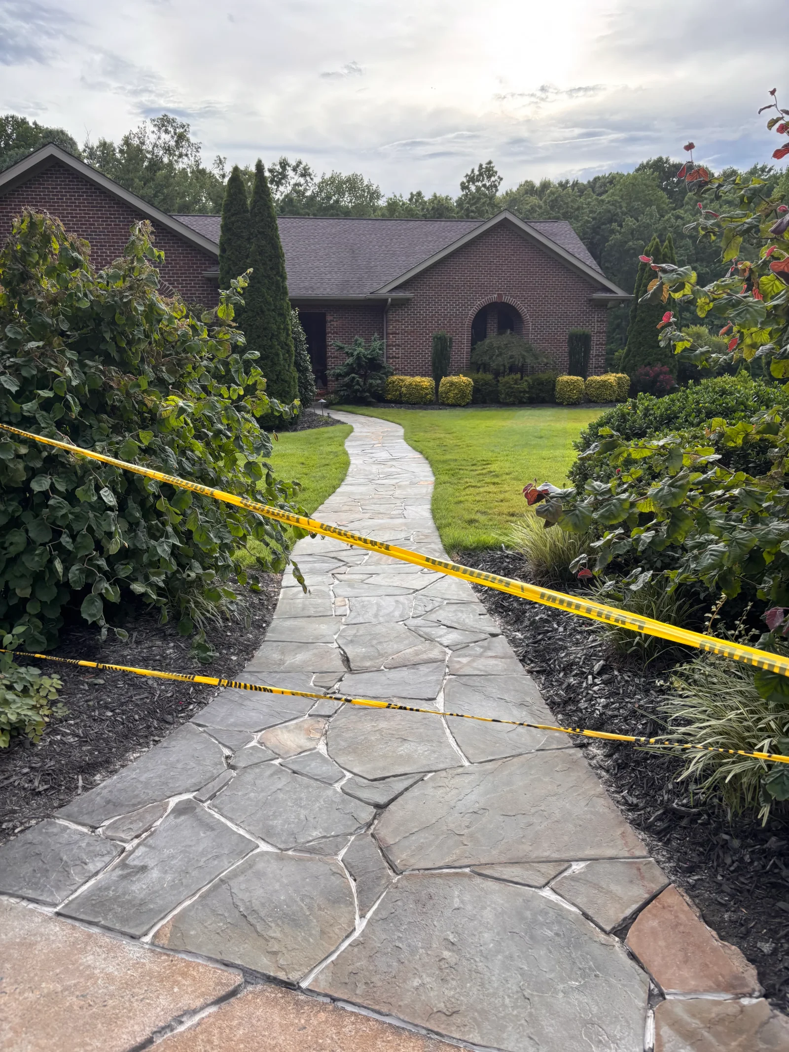 Irregular flagstone walkway with light mortar joints leading to brick home entrance