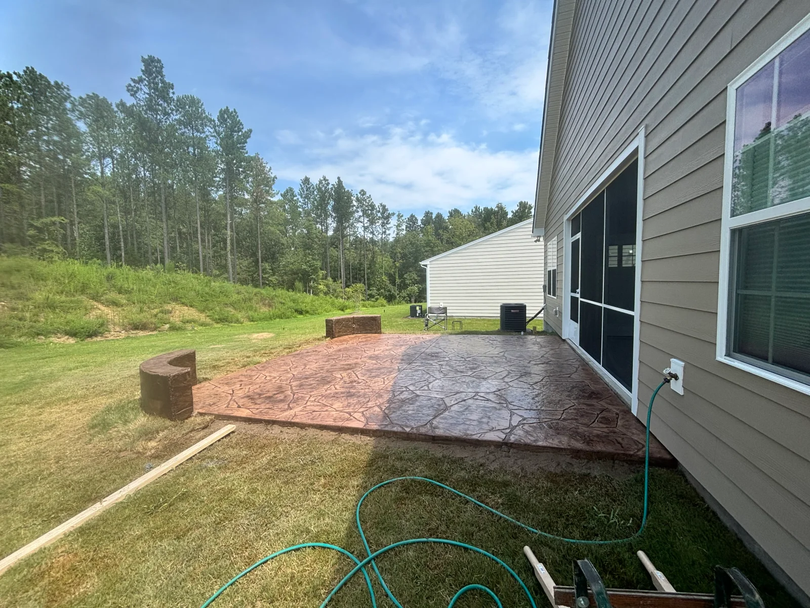 Stamped concrete patio with stone pattern finish next to residential home